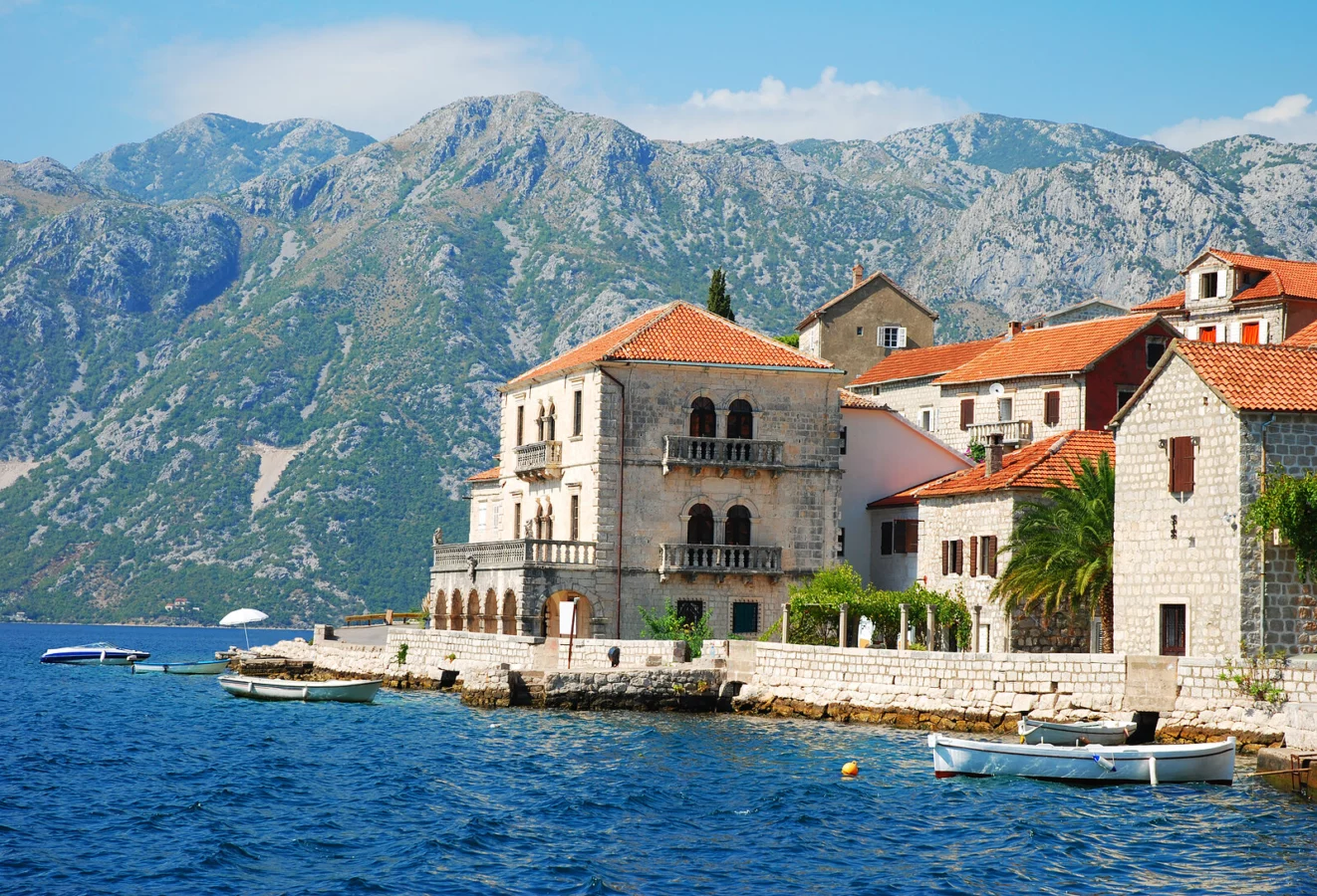 Scenic view of a picturesque coastal town surrounded by mountains and clear blue waters in Montenegro.